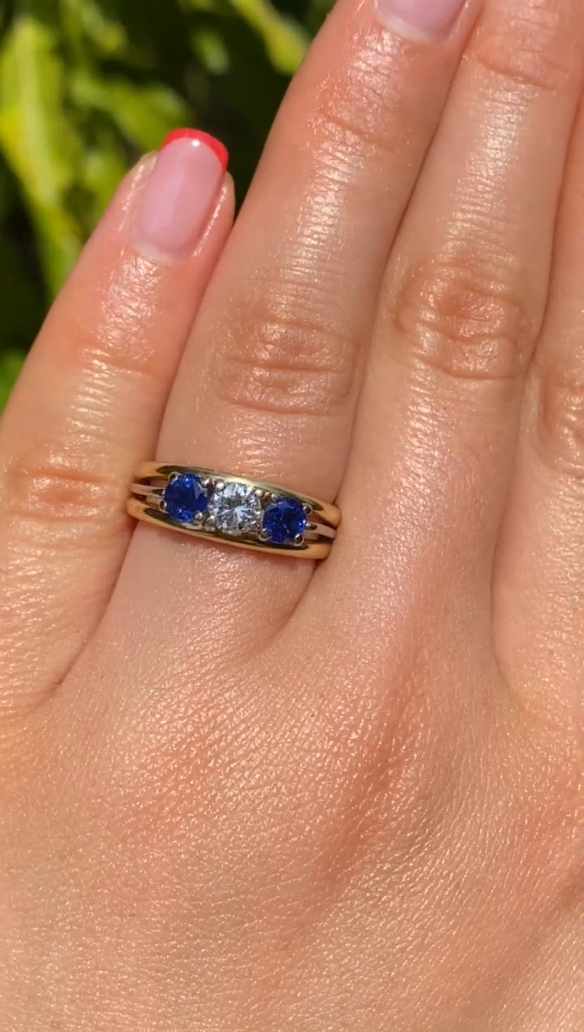 18K gold diamond and sapphire three-stone ring.