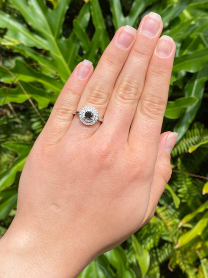 18K gold black and colourless diamond halo ring.