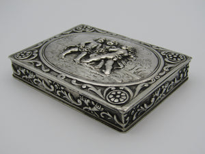 Continental silver table snuff box, stamped 800. The lid is embossed with scrolls and cherubs.